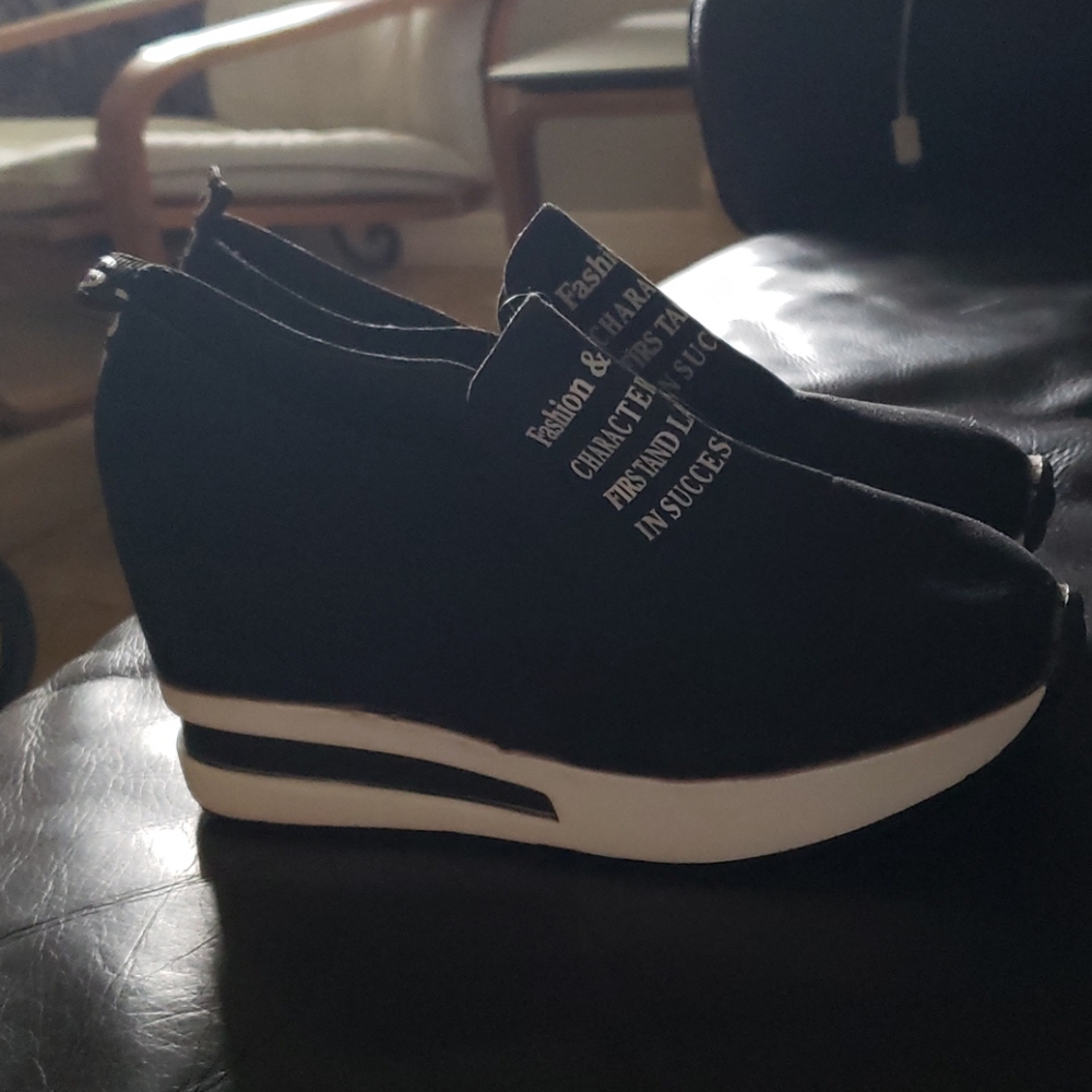 Black platform sneakers with writing on them